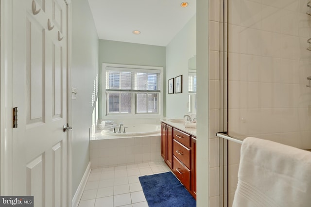 bathroom featuring tile patterned flooring, a garden tub, vanity, and tiled shower