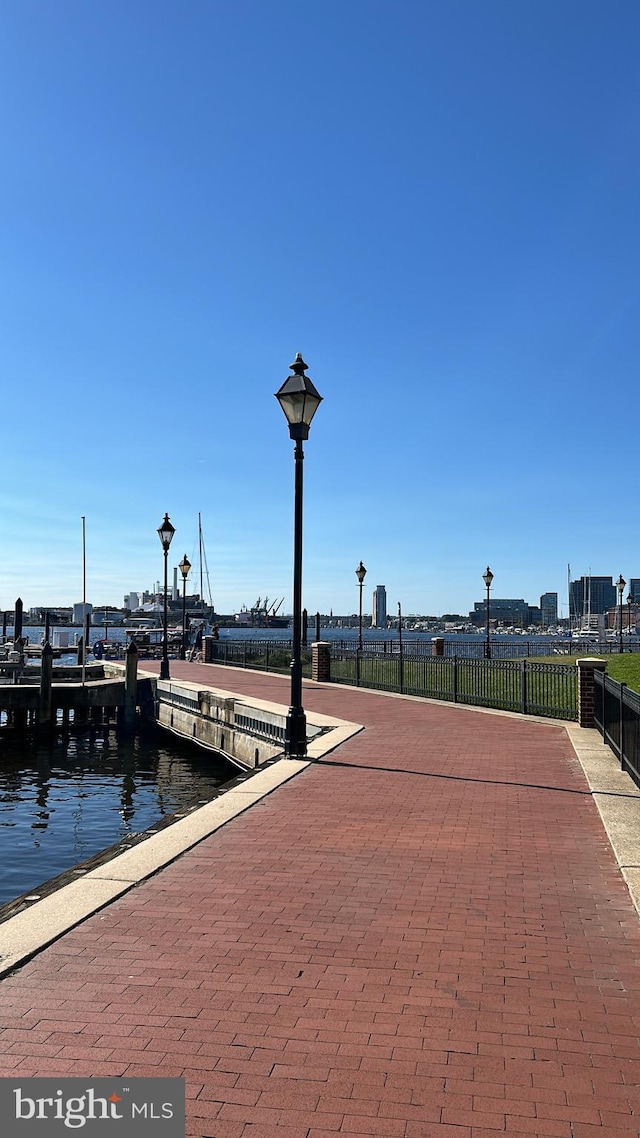 dock area with a water view and fence