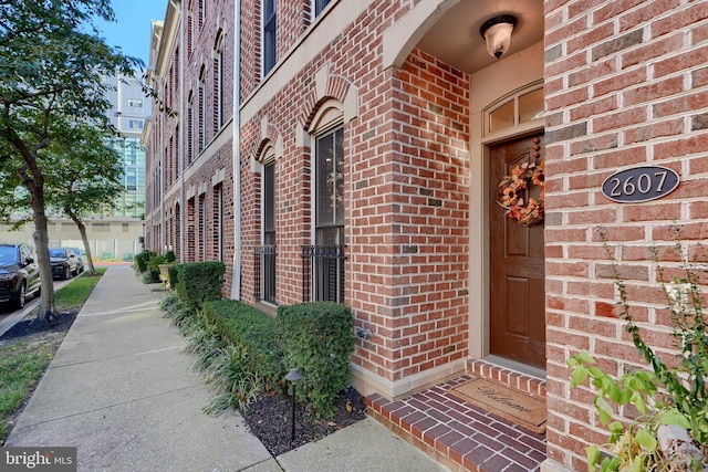 entrance to property featuring brick siding