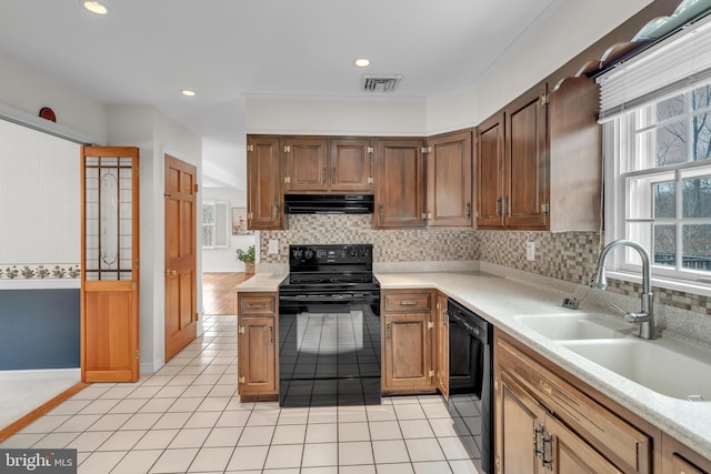 kitchen featuring visible vents, extractor fan, light tile patterned floors, black appliances, and a sink