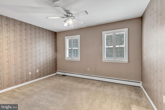 empty room featuring a baseboard radiator, carpet floors, baseboards, and a ceiling fan