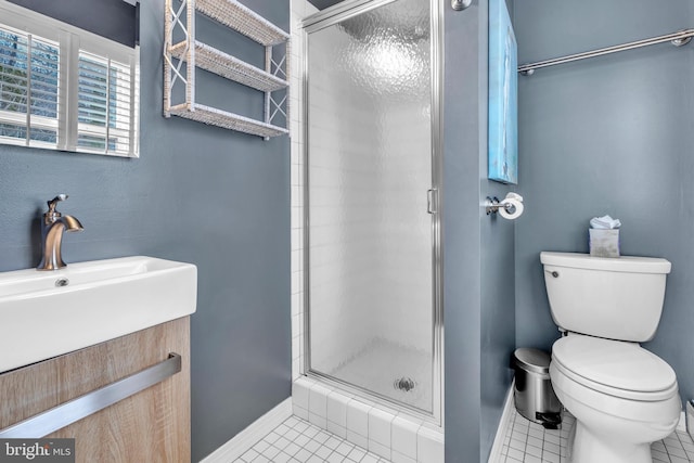 bathroom featuring vanity, toilet, a shower stall, and tile patterned flooring