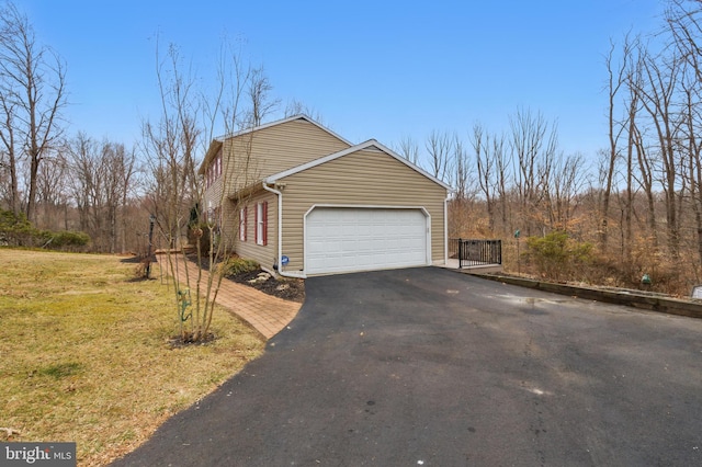 view of property exterior with aphalt driveway and a garage