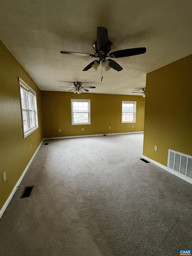 unfurnished room featuring carpet floors, visible vents, and a textured ceiling