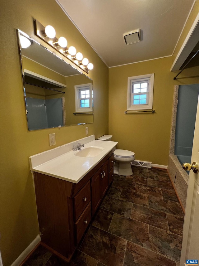 full bath featuring toilet, vanity, visible vents, and baseboards