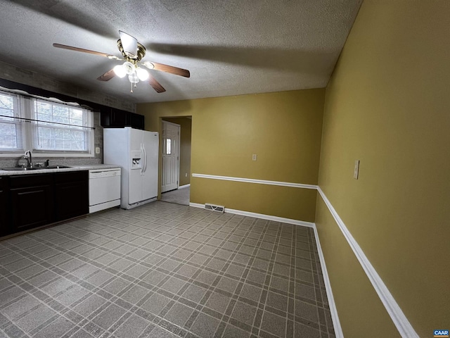 kitchen featuring white appliances, a sink, visible vents, baseboards, and light countertops