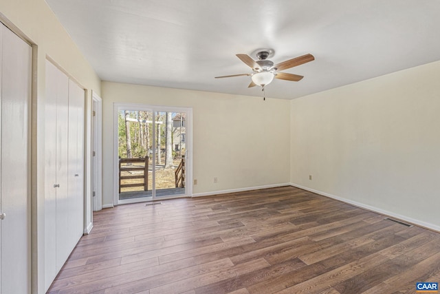 spare room with a ceiling fan, baseboards, visible vents, and wood finished floors