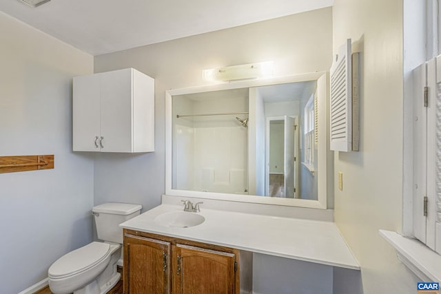 bathroom with vanity, toilet, and walk in shower