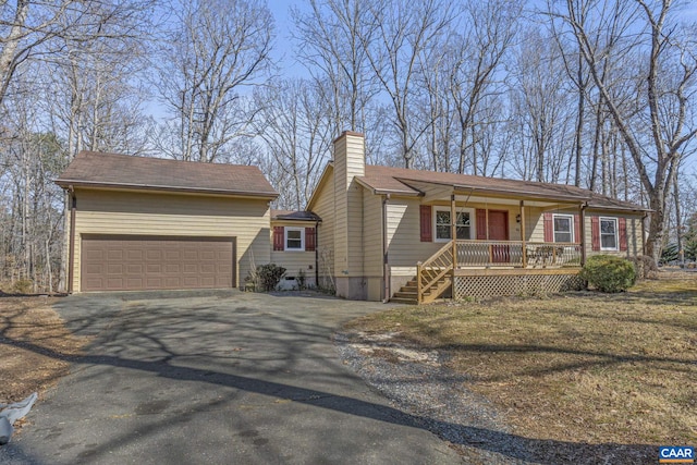 view of front facade featuring a porch, driveway, and a chimney