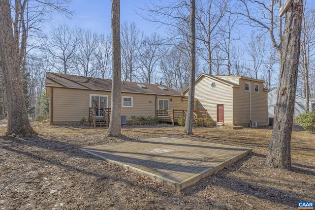 rear view of house featuring a deck and cooling unit