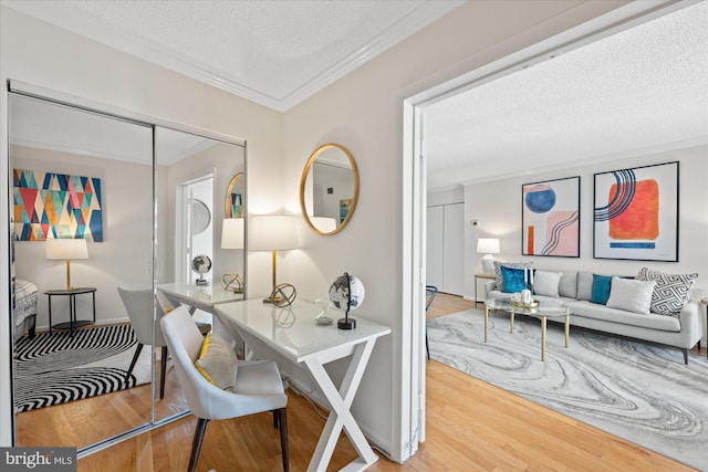 home office featuring a textured ceiling, ornamental molding, and wood finished floors