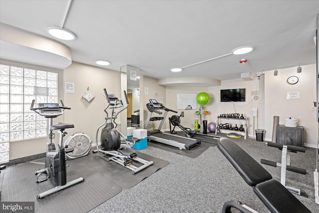 workout area with baseboards and track lighting