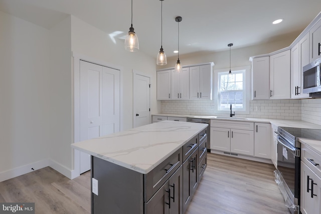 kitchen with electric range oven, backsplash, a sink, and light wood-style floors