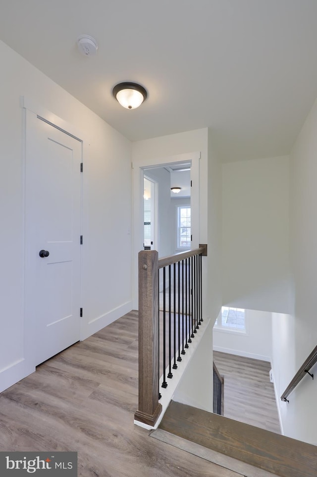 staircase with baseboards and wood finished floors