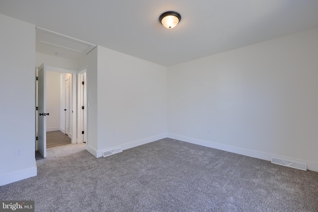 spare room with carpet flooring, visible vents, and baseboards