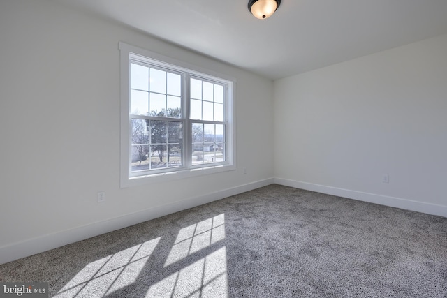 carpeted spare room with baseboards