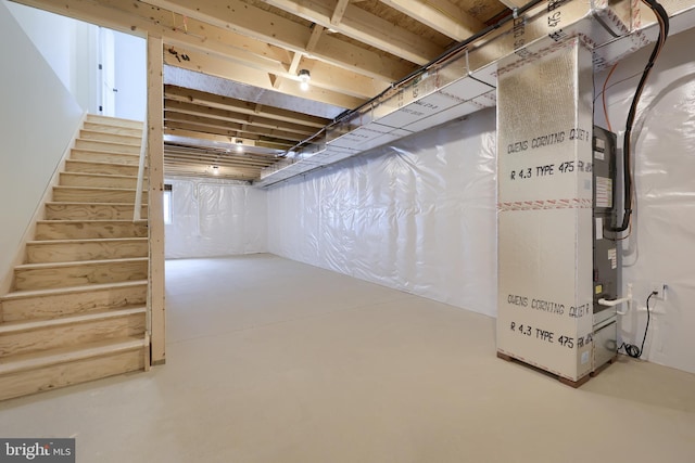 unfinished basement with heating unit and stairs