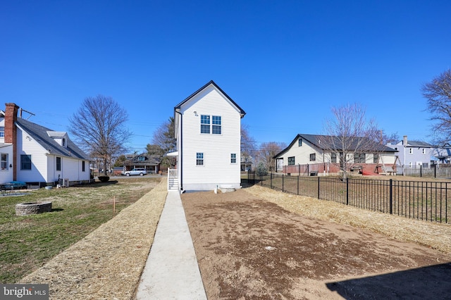 view of side of home with a residential view and fence