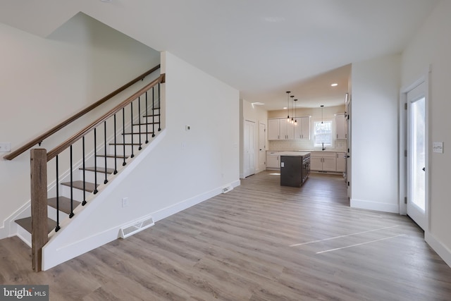 interior space featuring wood finished floors, visible vents, and baseboards