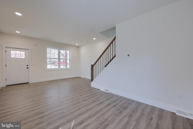 foyer with visible vents, baseboards, light wood-style flooring, stairs, and recessed lighting