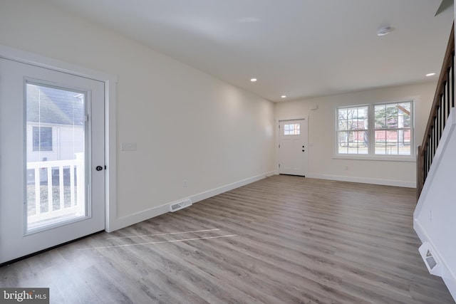 interior space with recessed lighting, wood finished floors, visible vents, baseboards, and stairs