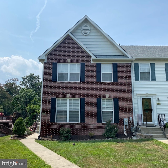 view of front of house with a front yard and brick siding