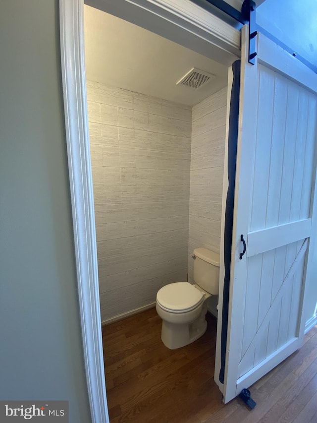bathroom featuring toilet, visible vents, and wood finished floors