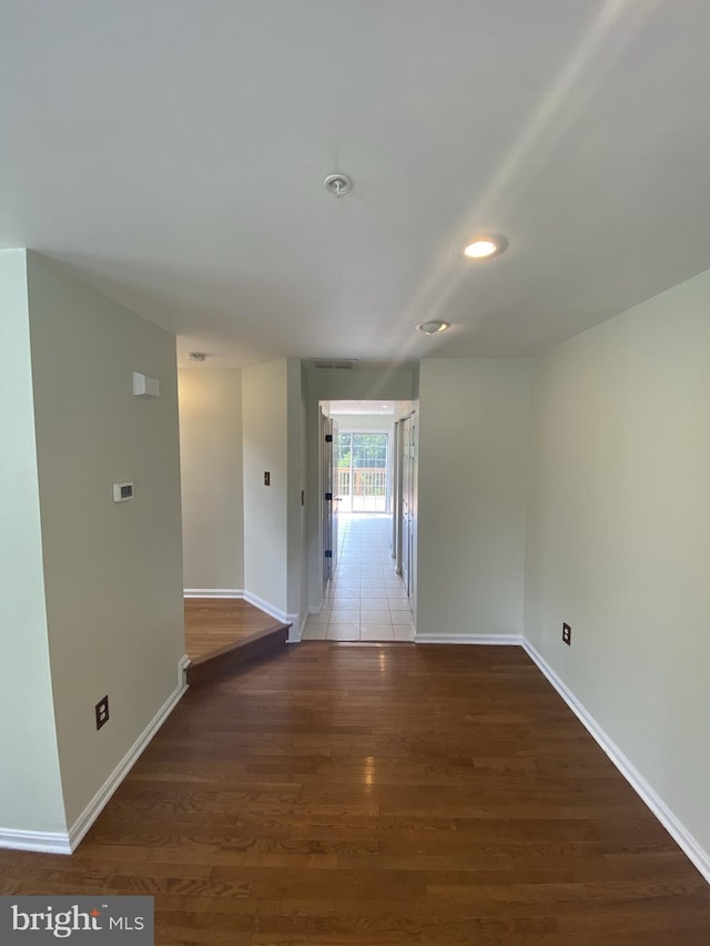 corridor featuring recessed lighting, wood finished floors, and baseboards