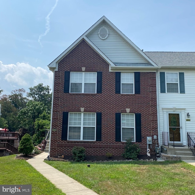 view of front facade with a front yard and brick siding