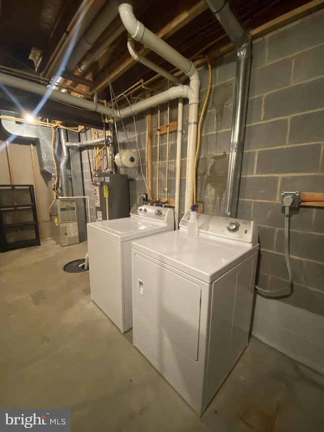 washroom with heating unit, laundry area, water heater, and separate washer and dryer