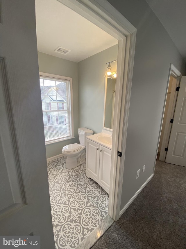 bathroom featuring toilet, baseboards, visible vents, and vanity