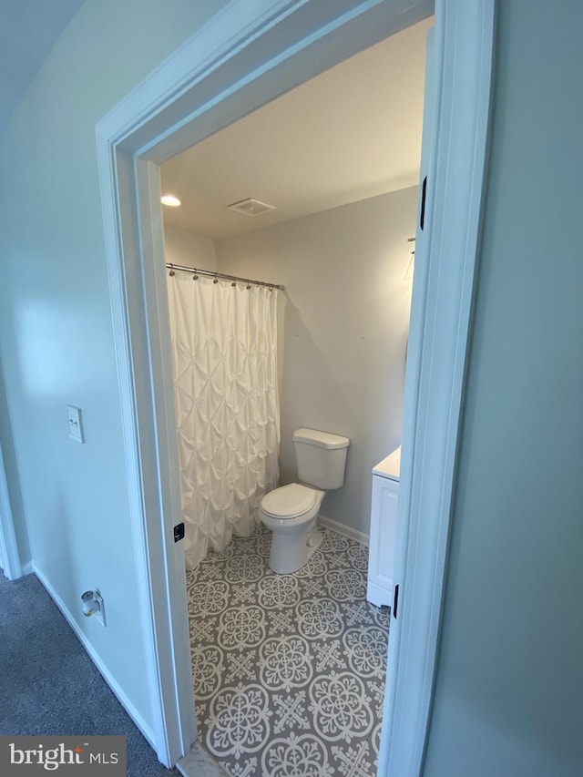 bathroom featuring visible vents, toilet, vanity, tile patterned flooring, and baseboards