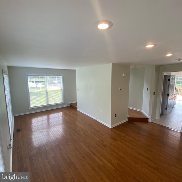 empty room with plenty of natural light, baseboards, and hardwood / wood-style flooring