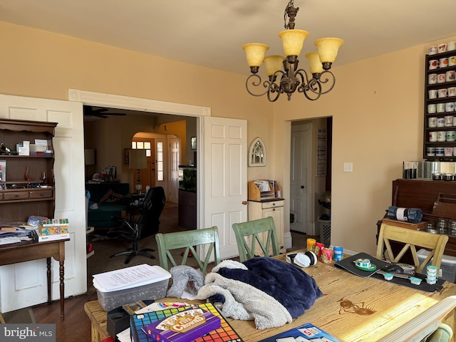 dining room with arched walkways, a notable chandelier, and wood finished floors