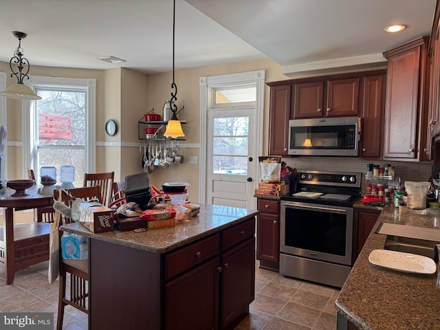 kitchen with a wealth of natural light, backsplash, and appliances with stainless steel finishes