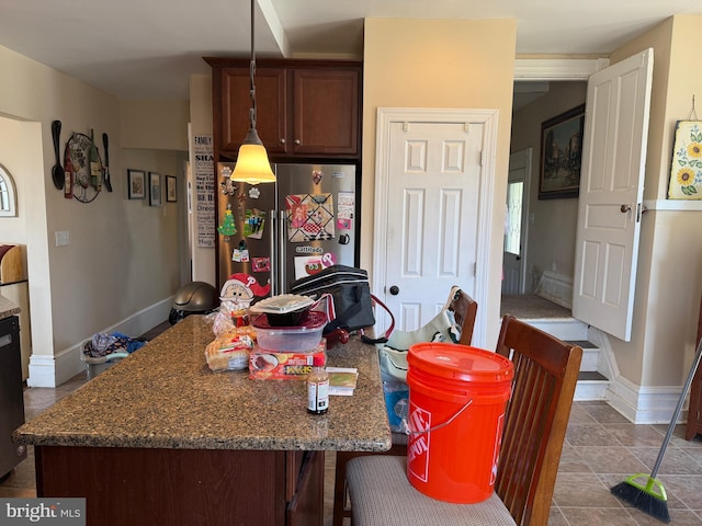 kitchen with dark stone counters, baseboards, and tile patterned flooring