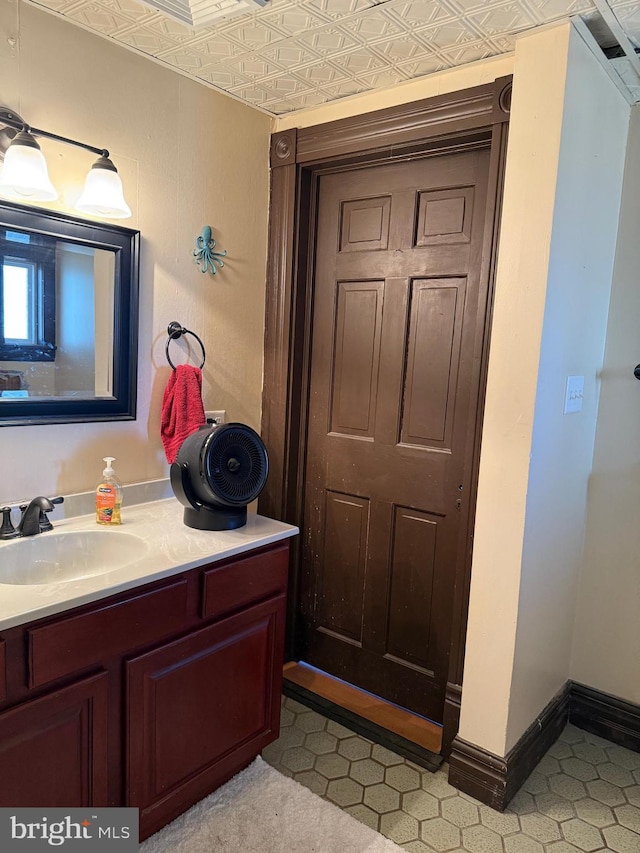 bathroom featuring vanity, baseboards, and an ornate ceiling