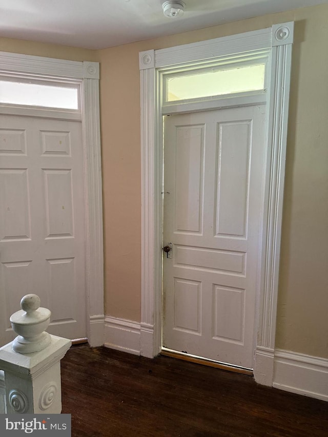 foyer featuring dark wood-type flooring and baseboards