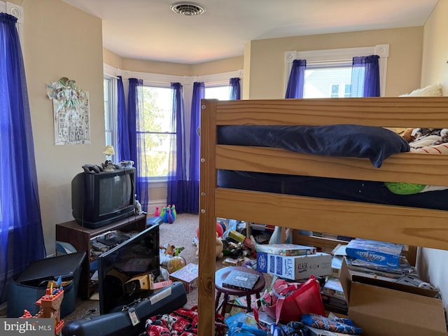 carpeted bedroom featuring visible vents