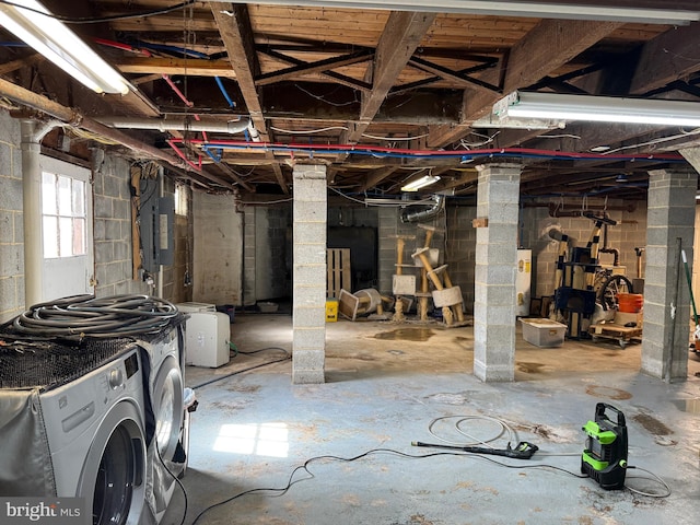 below grade area featuring electric panel, separate washer and dryer, and water heater