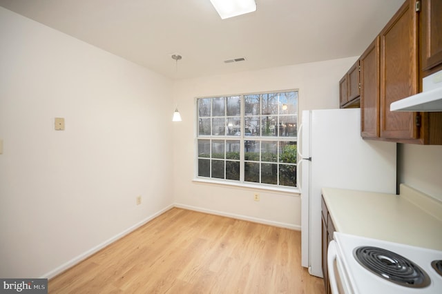 kitchen featuring light wood-style flooring, visible vents, brown cabinets, and baseboards