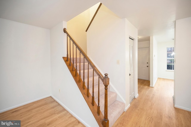 staircase with baseboards and wood finished floors