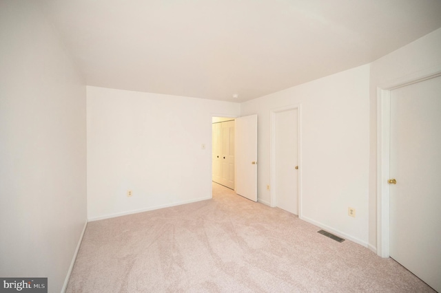 unfurnished bedroom with light carpet, visible vents, and baseboards