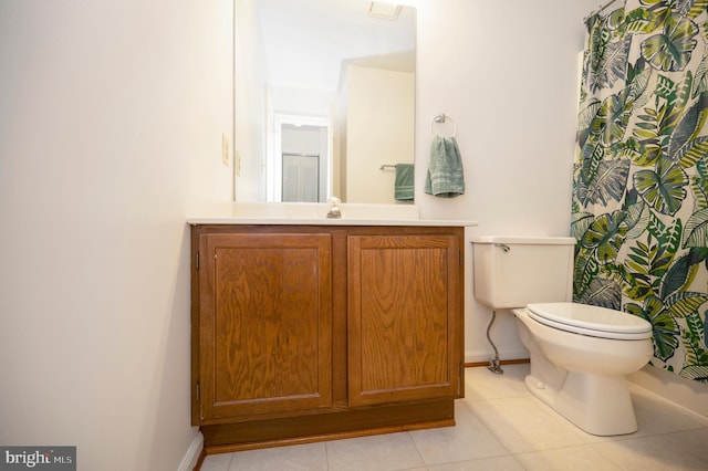 bathroom featuring toilet, tile patterned flooring, baseboards, and vanity