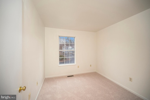 spare room featuring carpet floors, baseboards, and visible vents