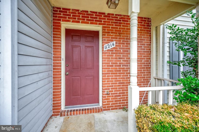 view of exterior entry with brick siding