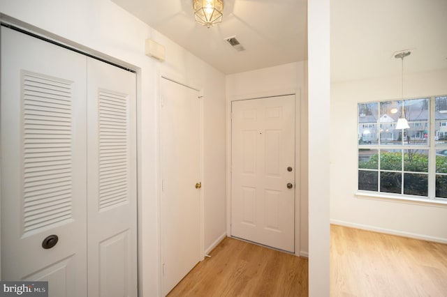 interior space with light wood-type flooring, baseboards, and visible vents