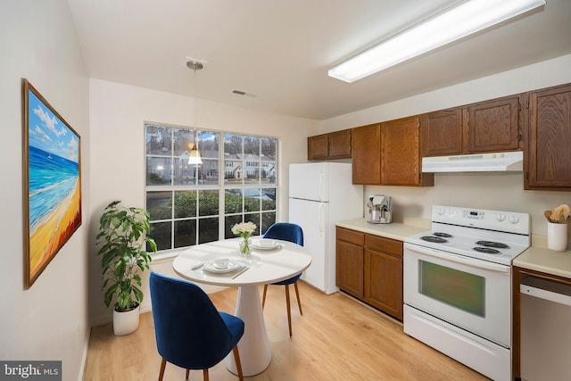 kitchen featuring light countertops, visible vents, light wood-style flooring, white appliances, and under cabinet range hood