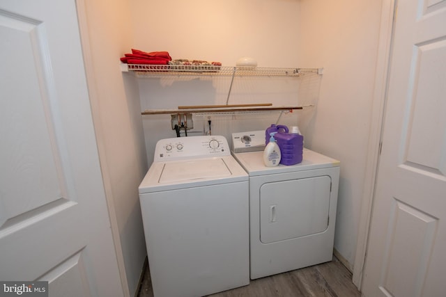 clothes washing area featuring laundry area, light wood-style flooring, and washer and dryer