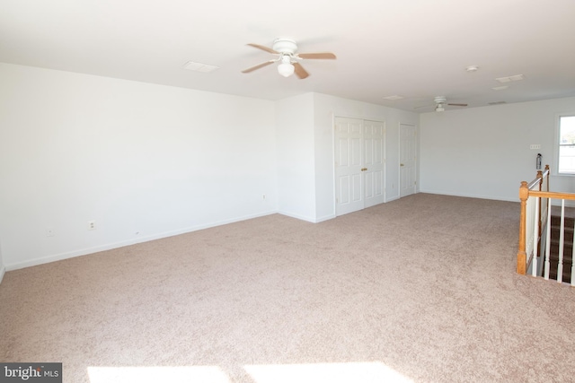 carpeted empty room featuring baseboards and ceiling fan